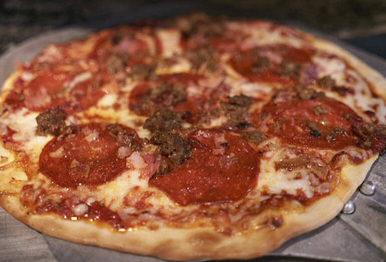 a small pepperoni pizza sitting on top of a pan