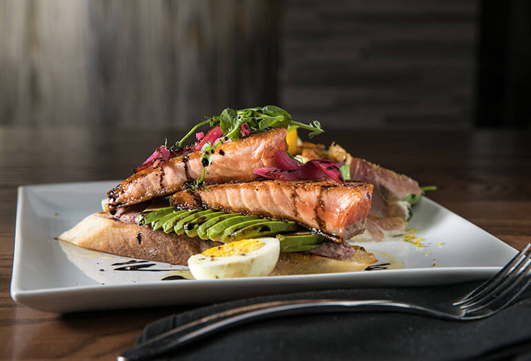 a sandwich sitting on top of a plate of food on a table