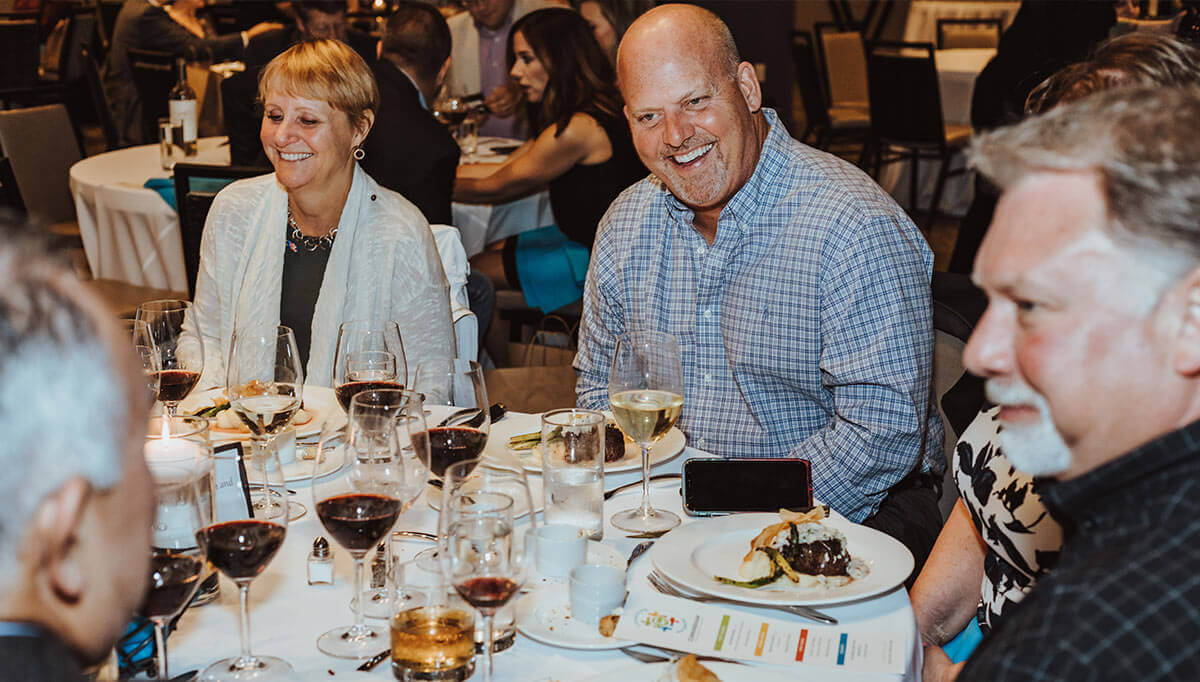 a group of people sitting at a table with wine glasses