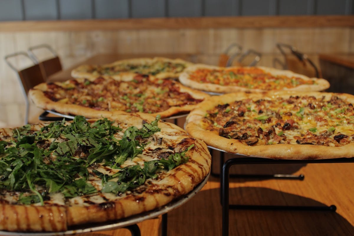 a pizza sitting on top of a wooden table