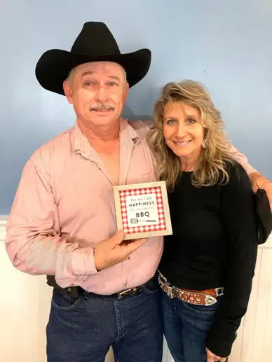 picture of a man wearing a hat and hugging a woman