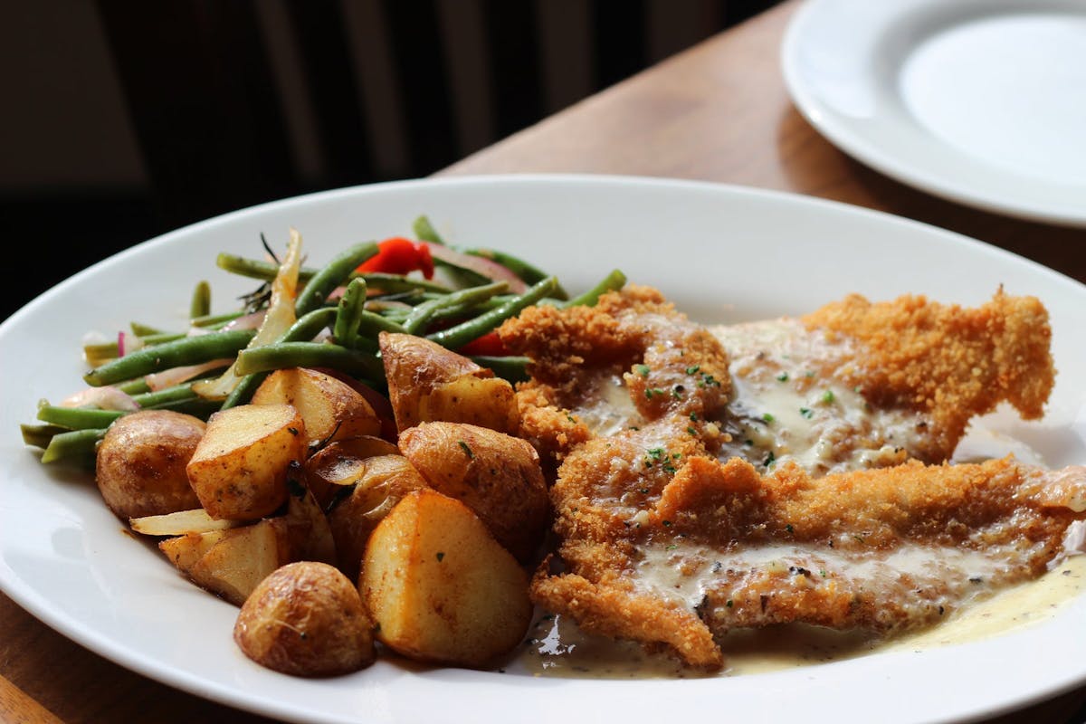 a white plate topped with meat and vegetables