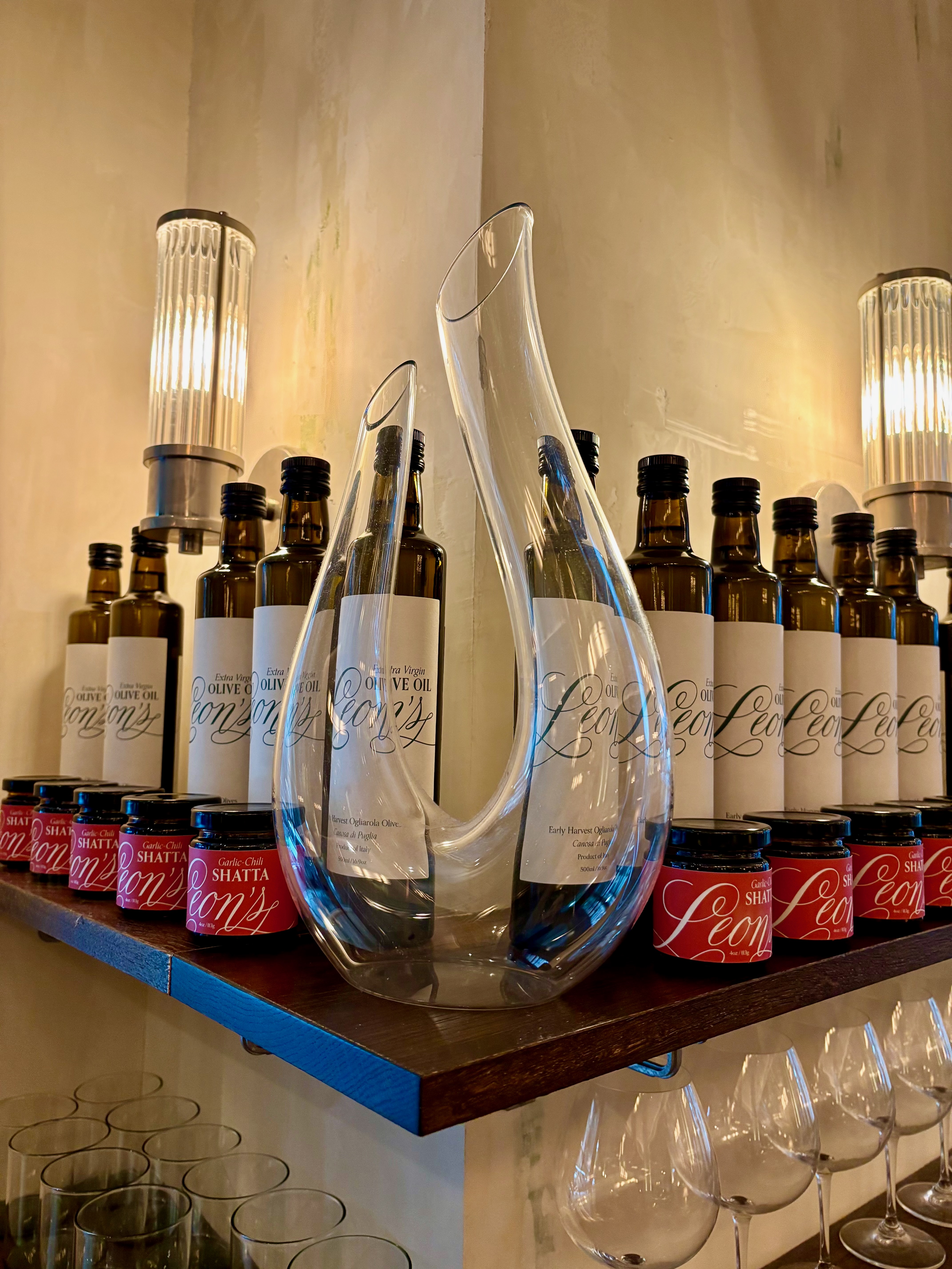 a glass vase on a shelf with bottles