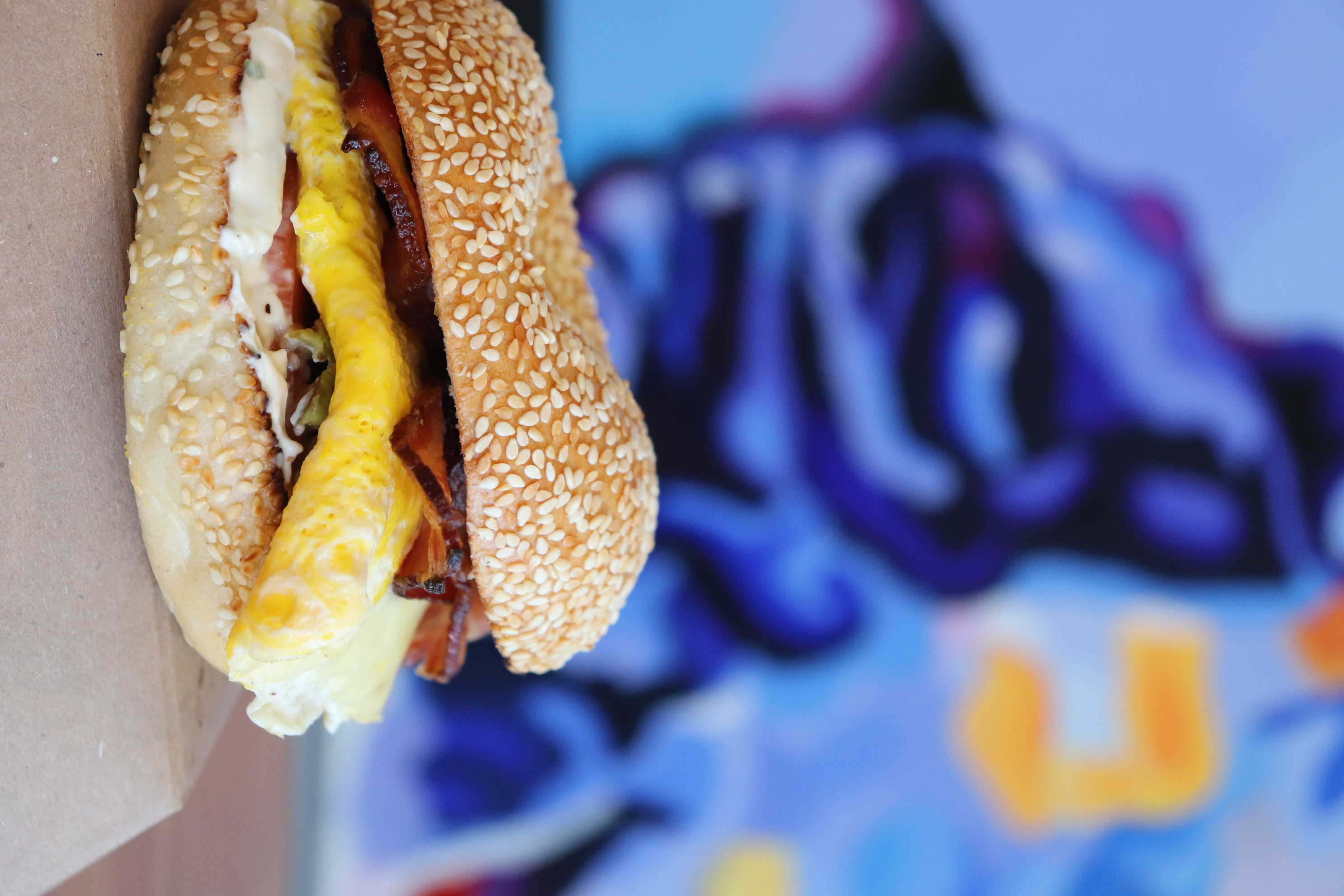 a sandwich with eggs bacon and mayo on a table