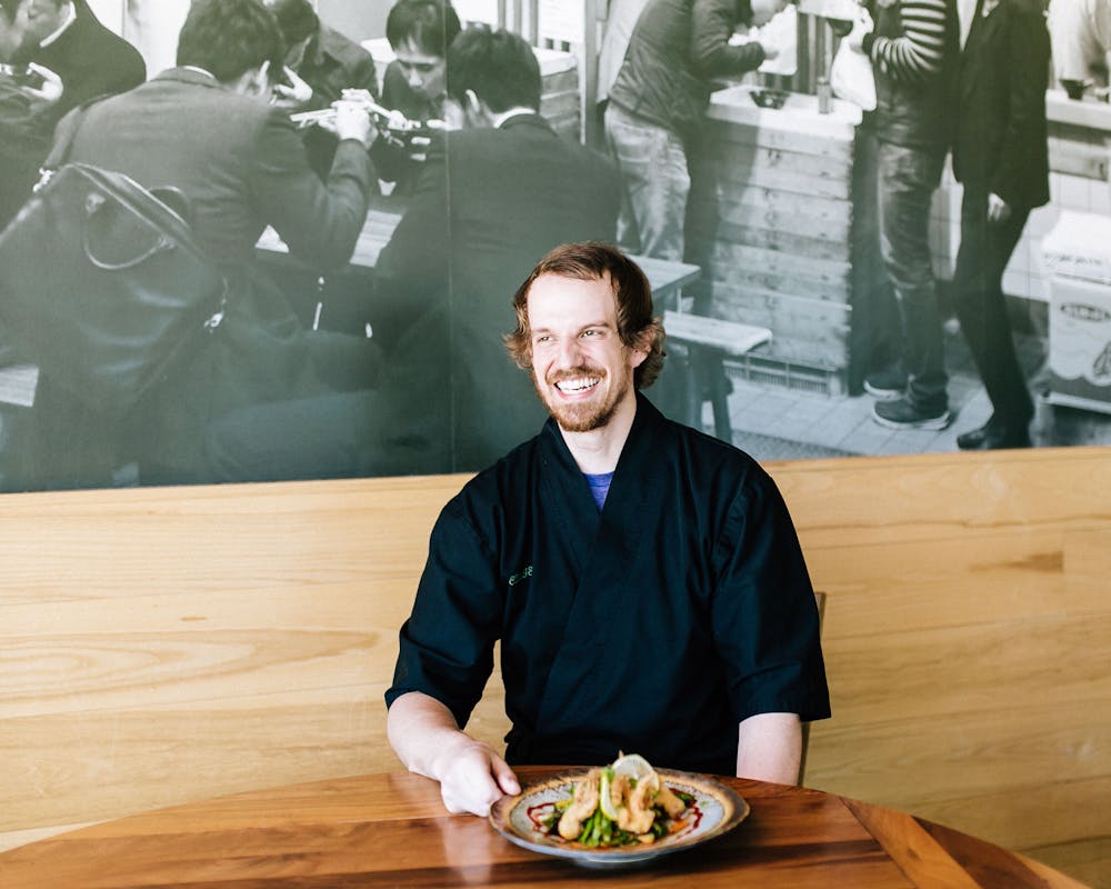 a man sitting at a table posing for the camera