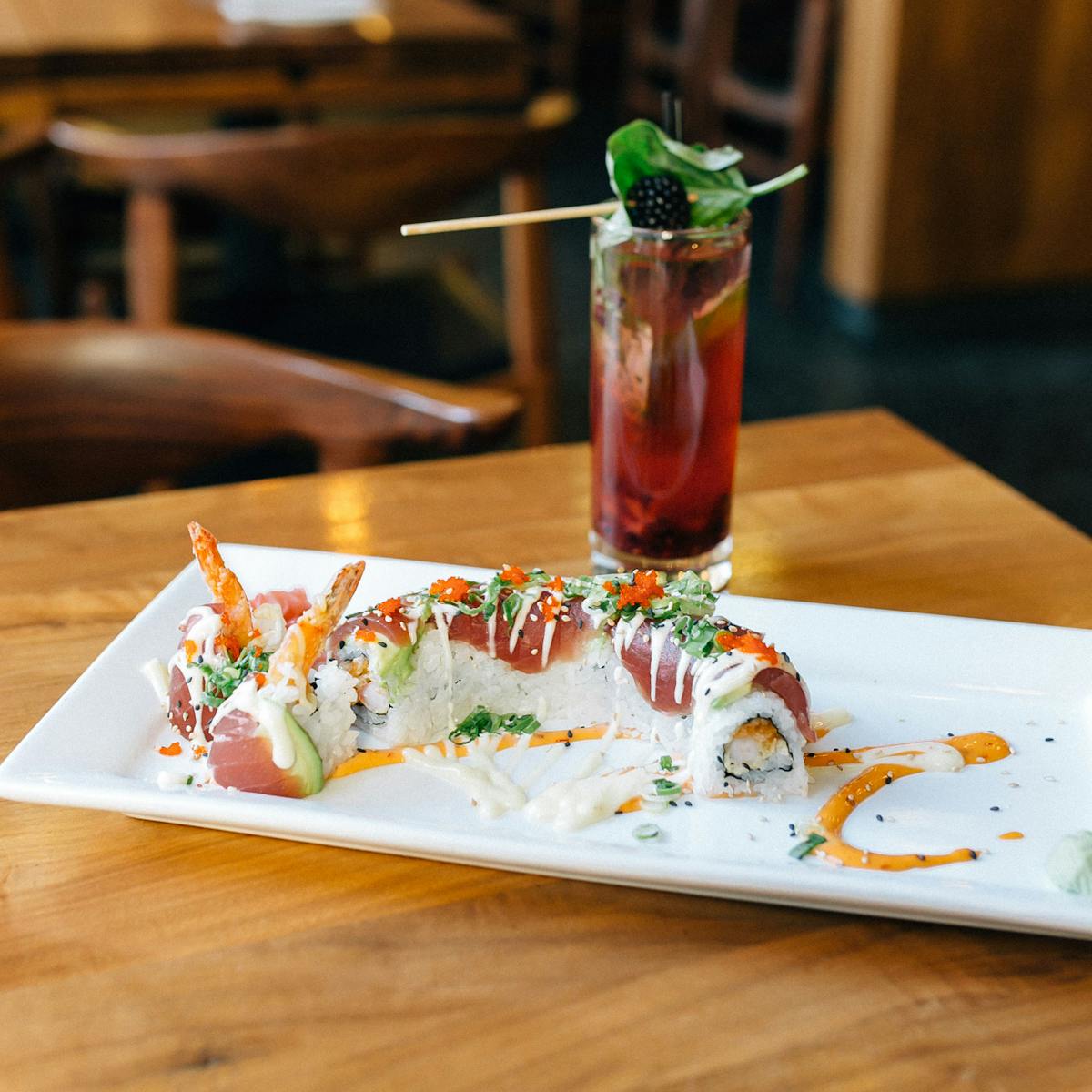 a sushi roll with a cocktail presented on a table