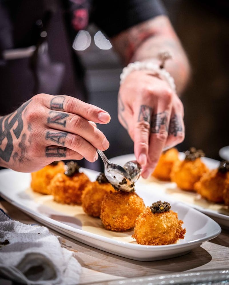 a person holding a plate of food on a table