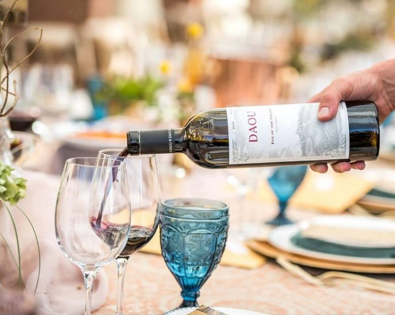 a person sitting at a table with wine glasses