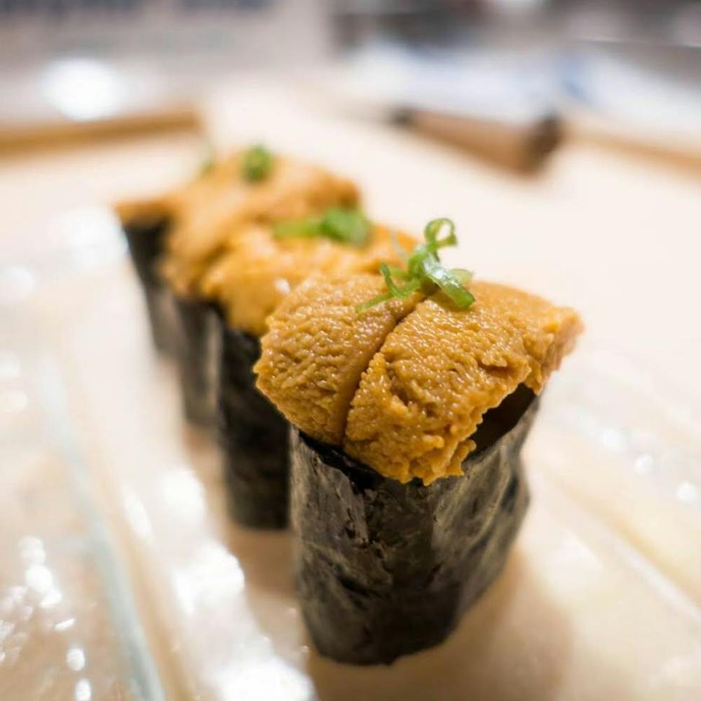 a piece of cake sitting on top of sushi on a table