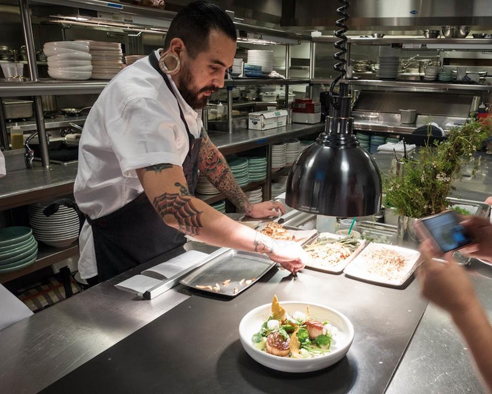 a man and woman preparing food in a restaurant