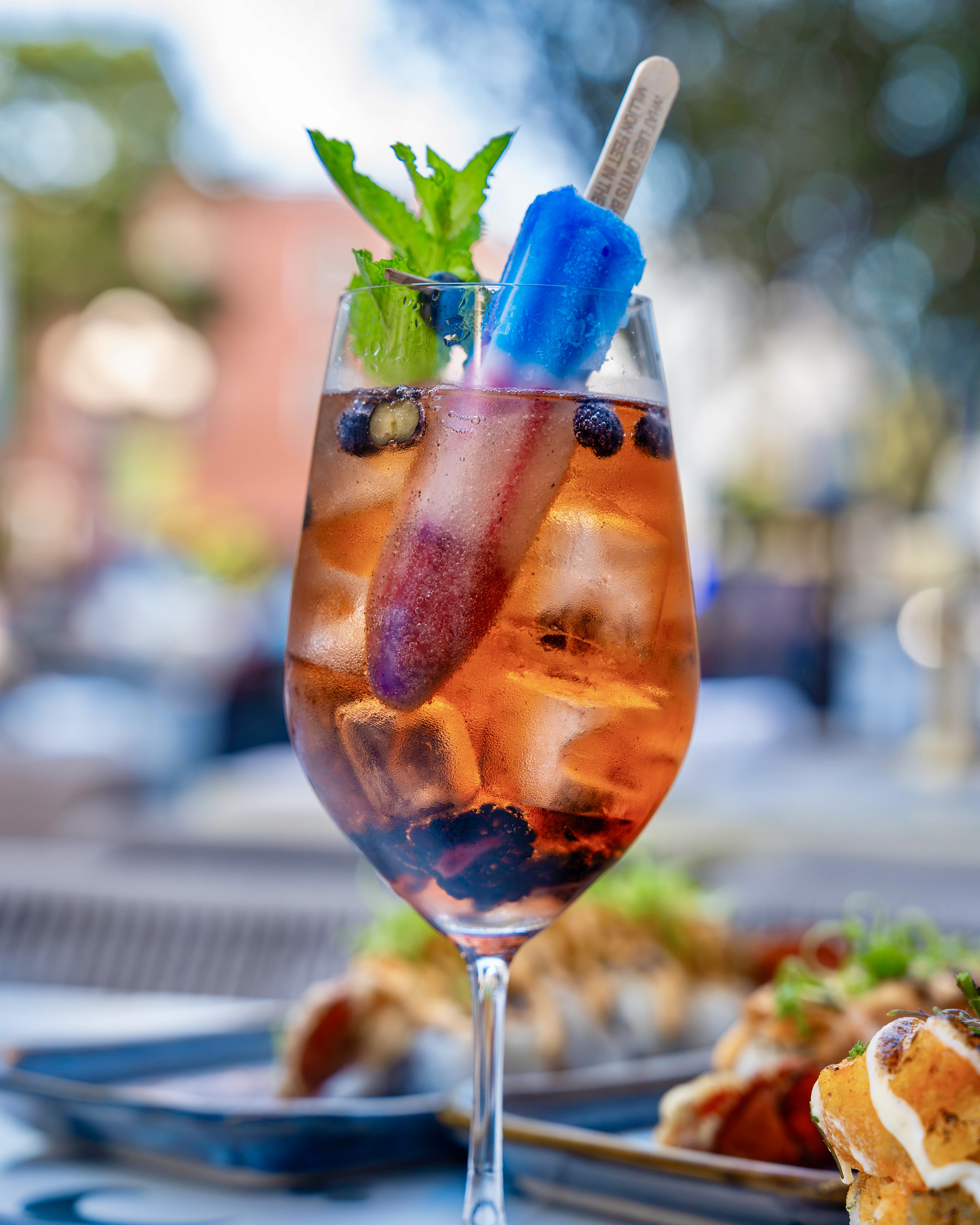 Guests enjoying Fourth of July dining at Lionfish in Downtown San Diego with fresh seafood, handcrafted sushi, a festive red, white and blue cocktail, and a limited-time lobster roll in the Gaslamp Quarter.
