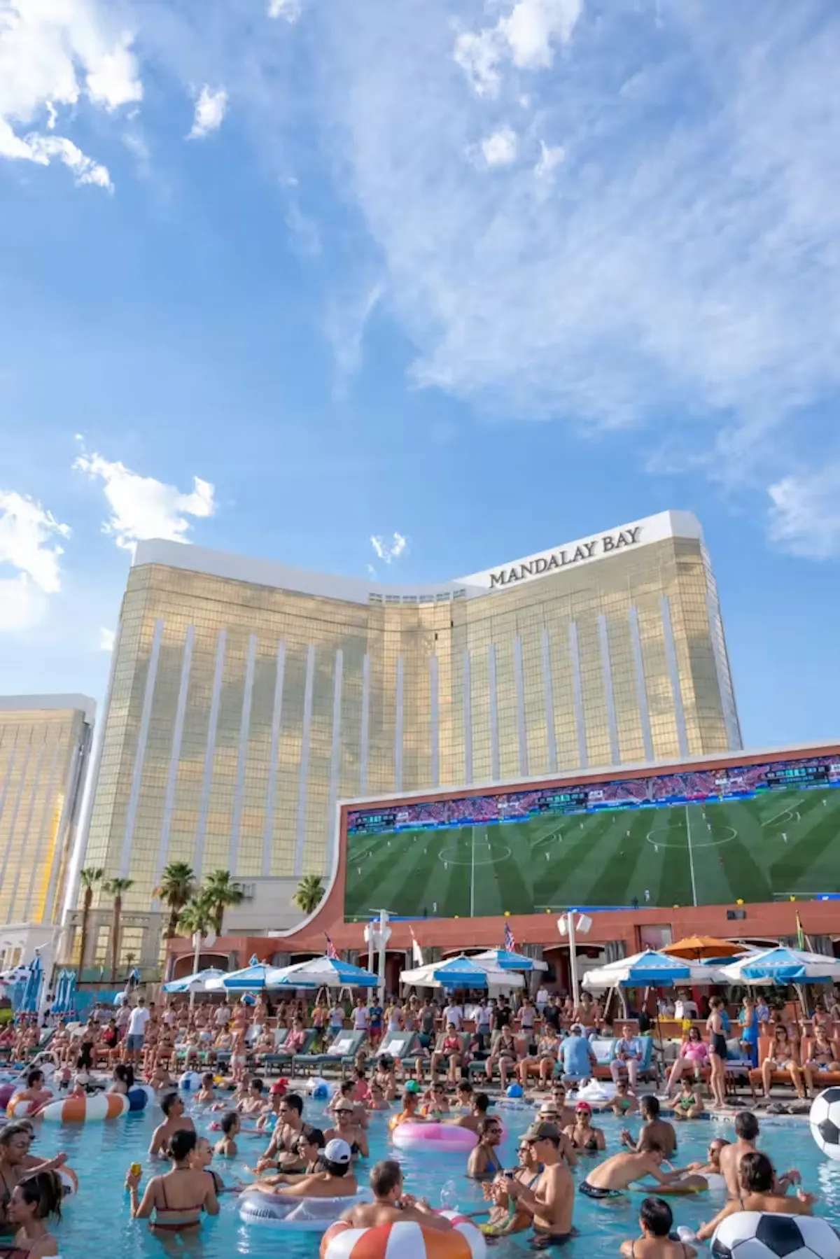 Mandalay Bay tower over packed crowd and game screen at Tailgate Beach Club