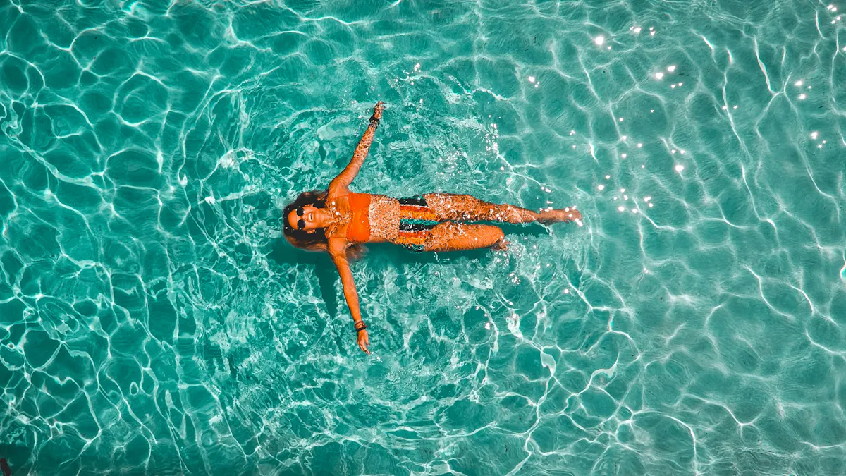 Overhead of woman floating in clear pool at Tailgate Beach Club