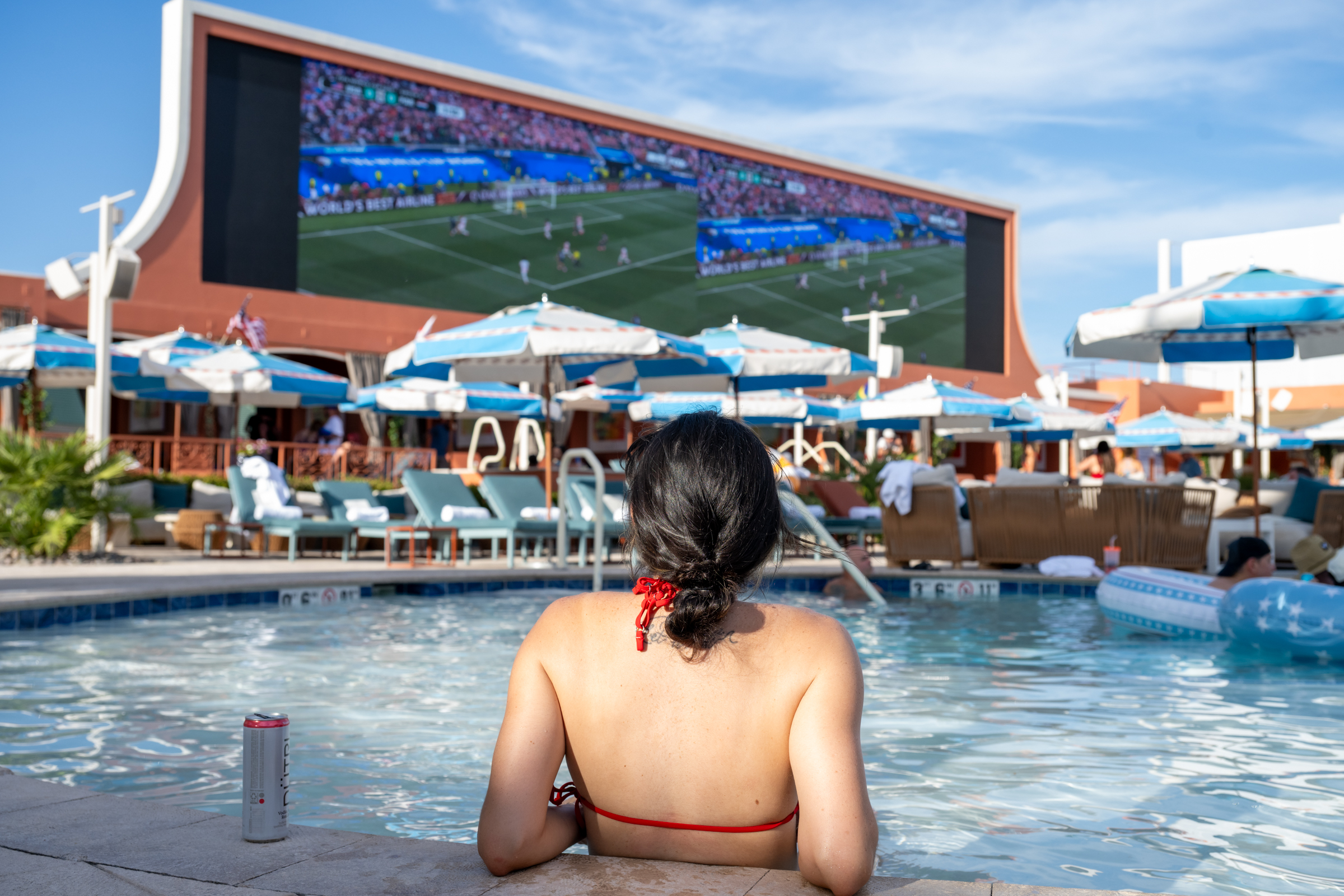 Sports fans at a Las Vegas pool party watching a game at Tailgate Beach Club