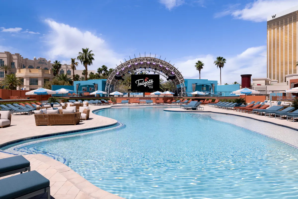Main pool sweep toward stage, palm trees, empty-venue beauty at Tailgate Beach Club