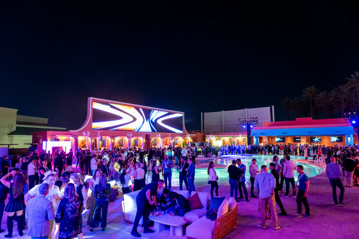 Nighttime party crowd with lit stage arch at Tailgate Beach Club