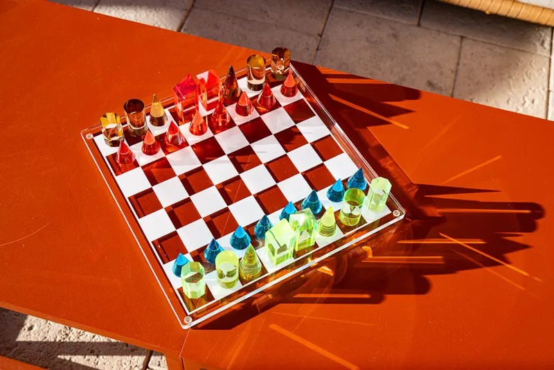 Custom chess set with shot glass pieces on a poolside table