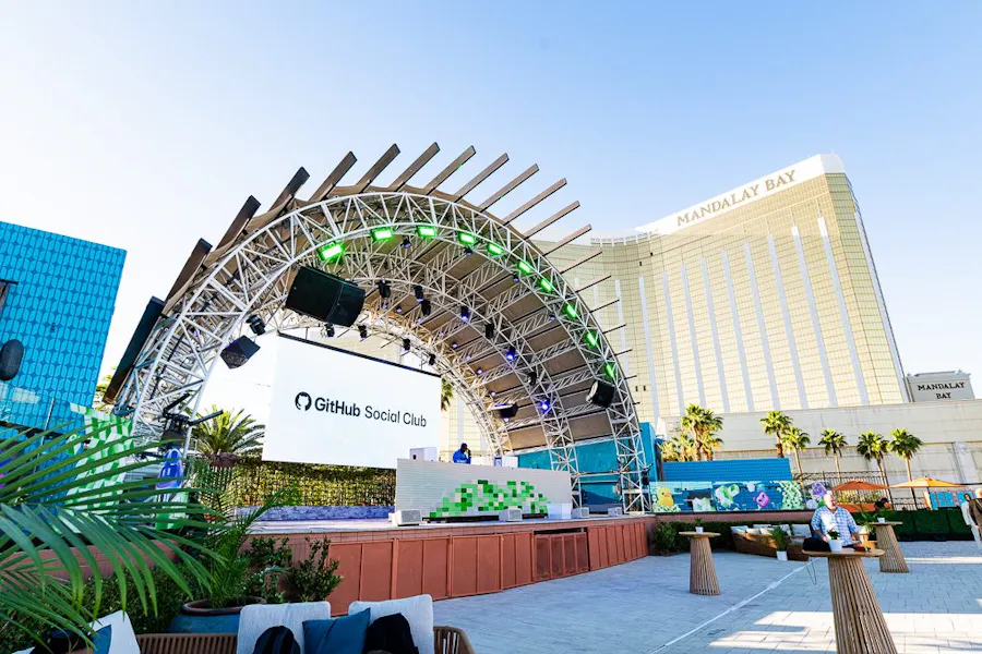 Stage arch with a custom welcome screen at a corporate event, daytime