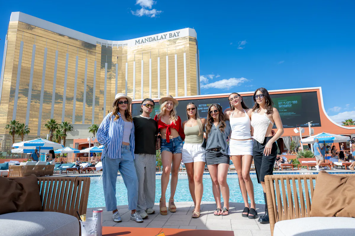 Group of five friends lined up poolside at Tailgate Beach Club