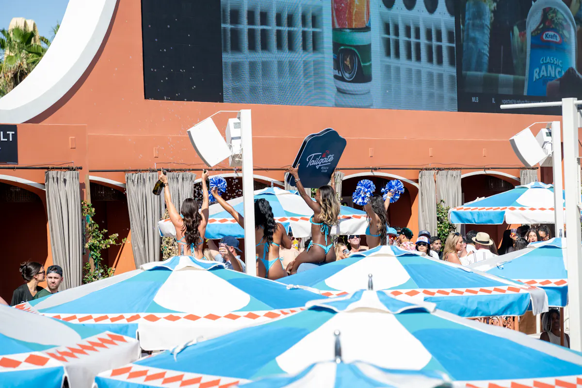 Overhead sea of branded umbrellas with LED screens at Tailgate Beach Club