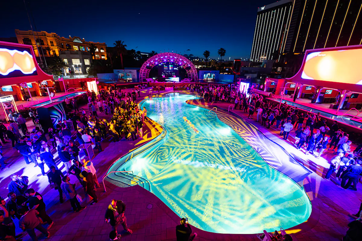 Night aerial of LED-lit pool party, Strip backdrop at Tailgate Beach Club