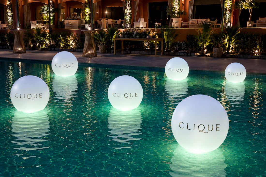 Custom-logo floating LED orbs in the pool at Tailgate Beach Club