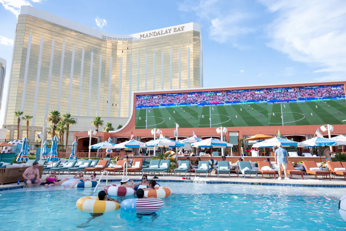 World Cup match on giant screen above pool full of floats at Tailgate Beach Club