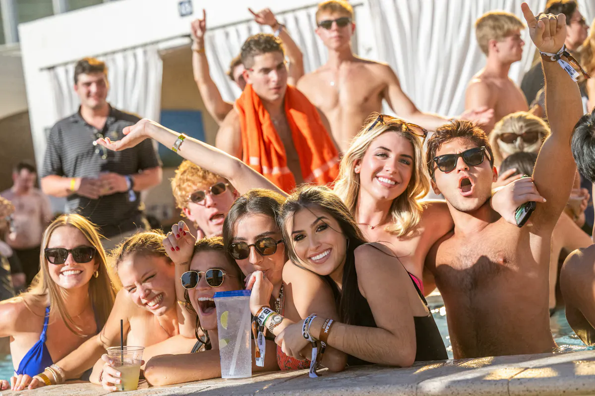 Young crowd cheering with drinks at dayclub at Tailgate Beach Club