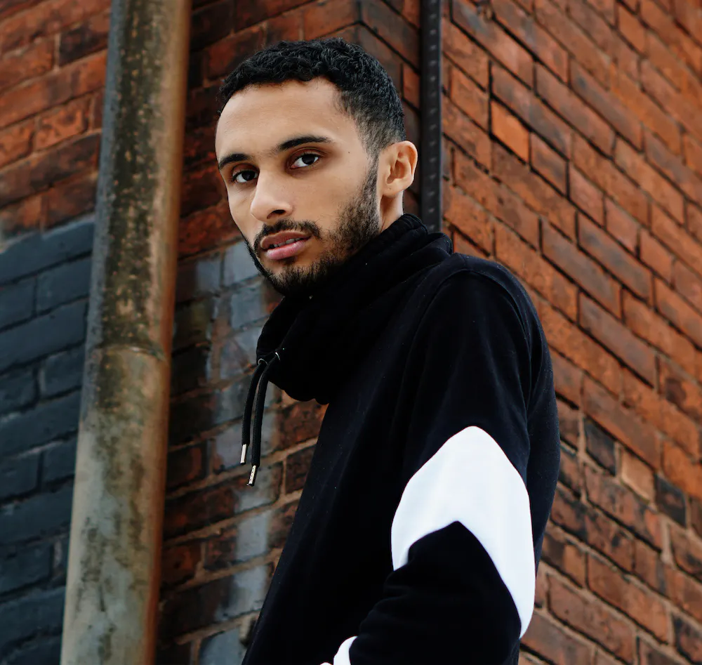 a man standing in front of a brick building