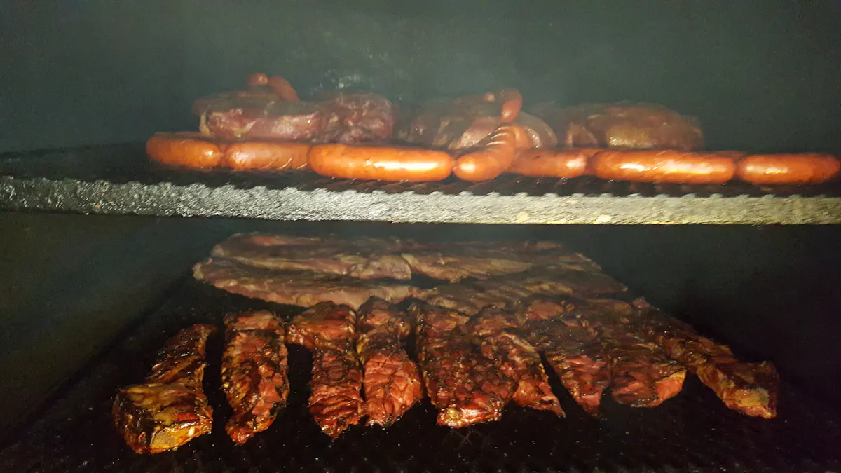 a tray of hot dogs cooking on a grill