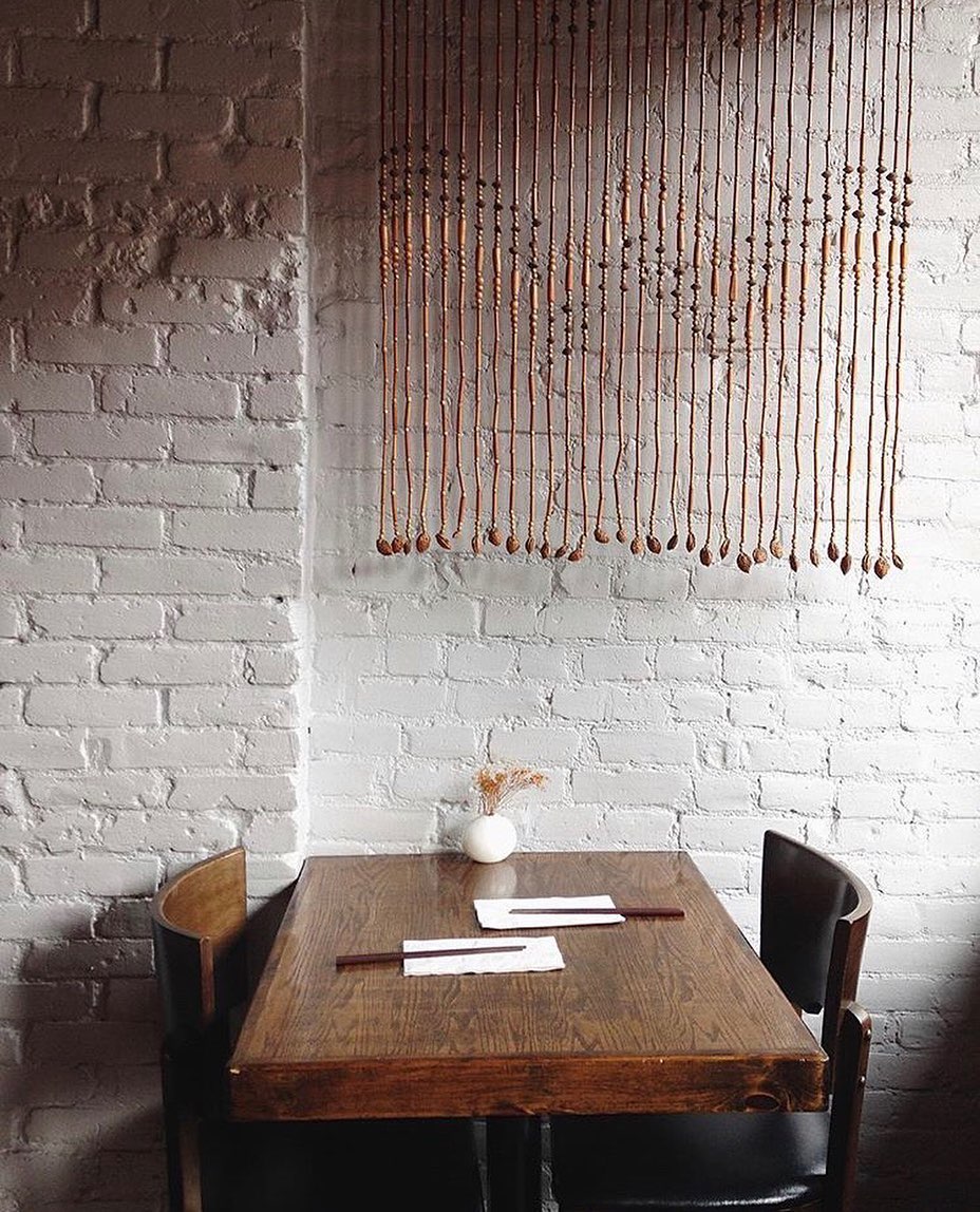 a wooden bench sitting next to a brick wall