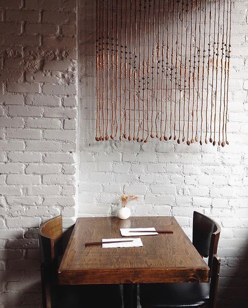 a wooden bench sitting next to a brick wall