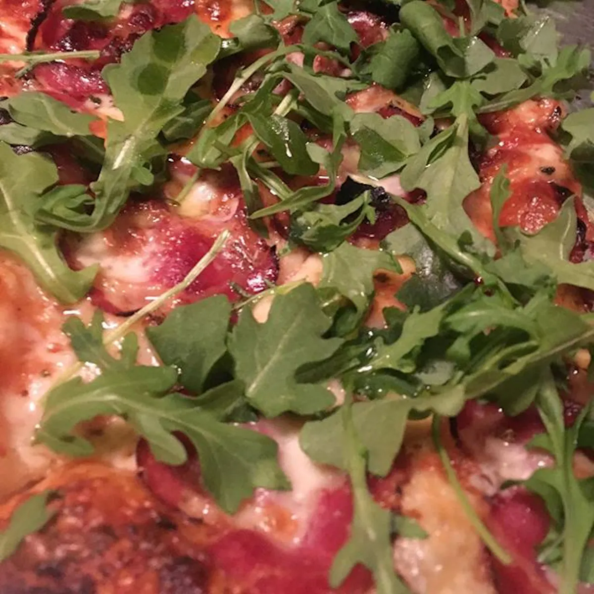 Spinach on top of a pizza