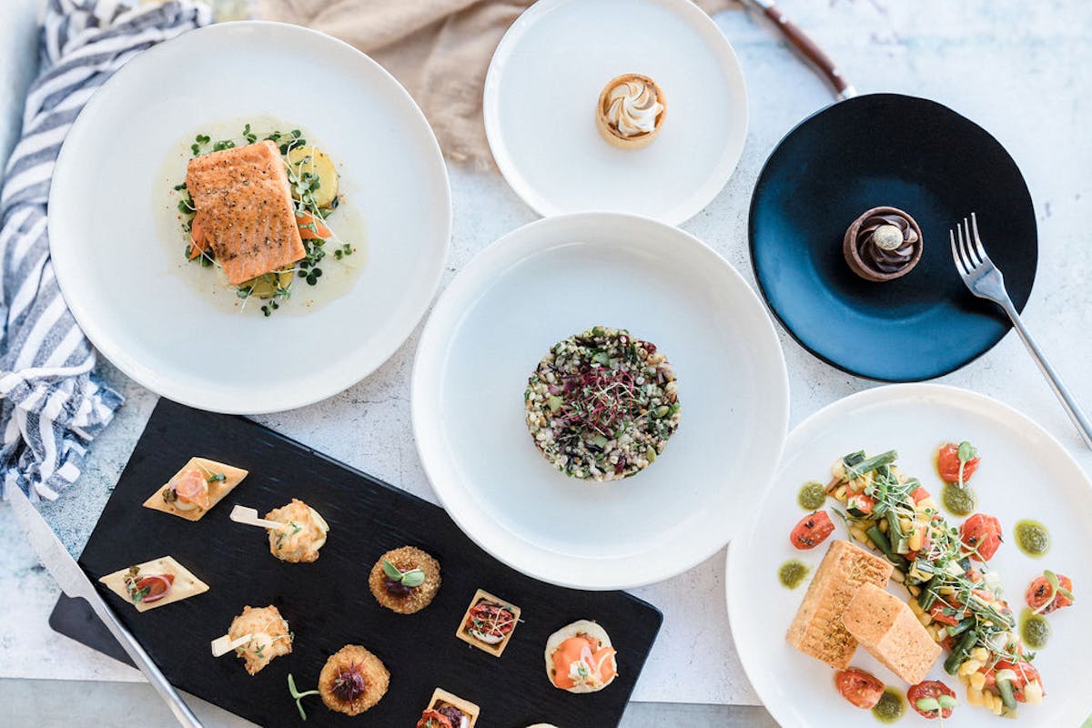 A vibrant display of gourmet dishes and fresh ingredients artfully arranged on a table, capturing the innovative culinary trends for 2025 in Vancouver catering