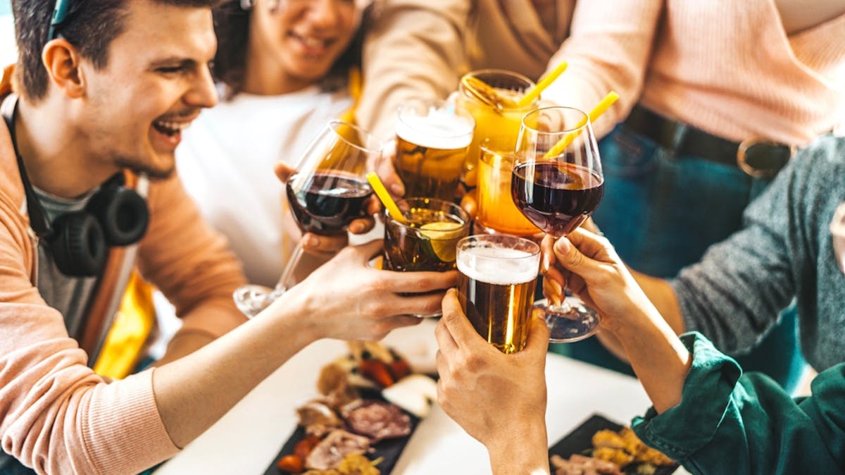 friends toasting with beer, whine, and cocktails on outdoor patio