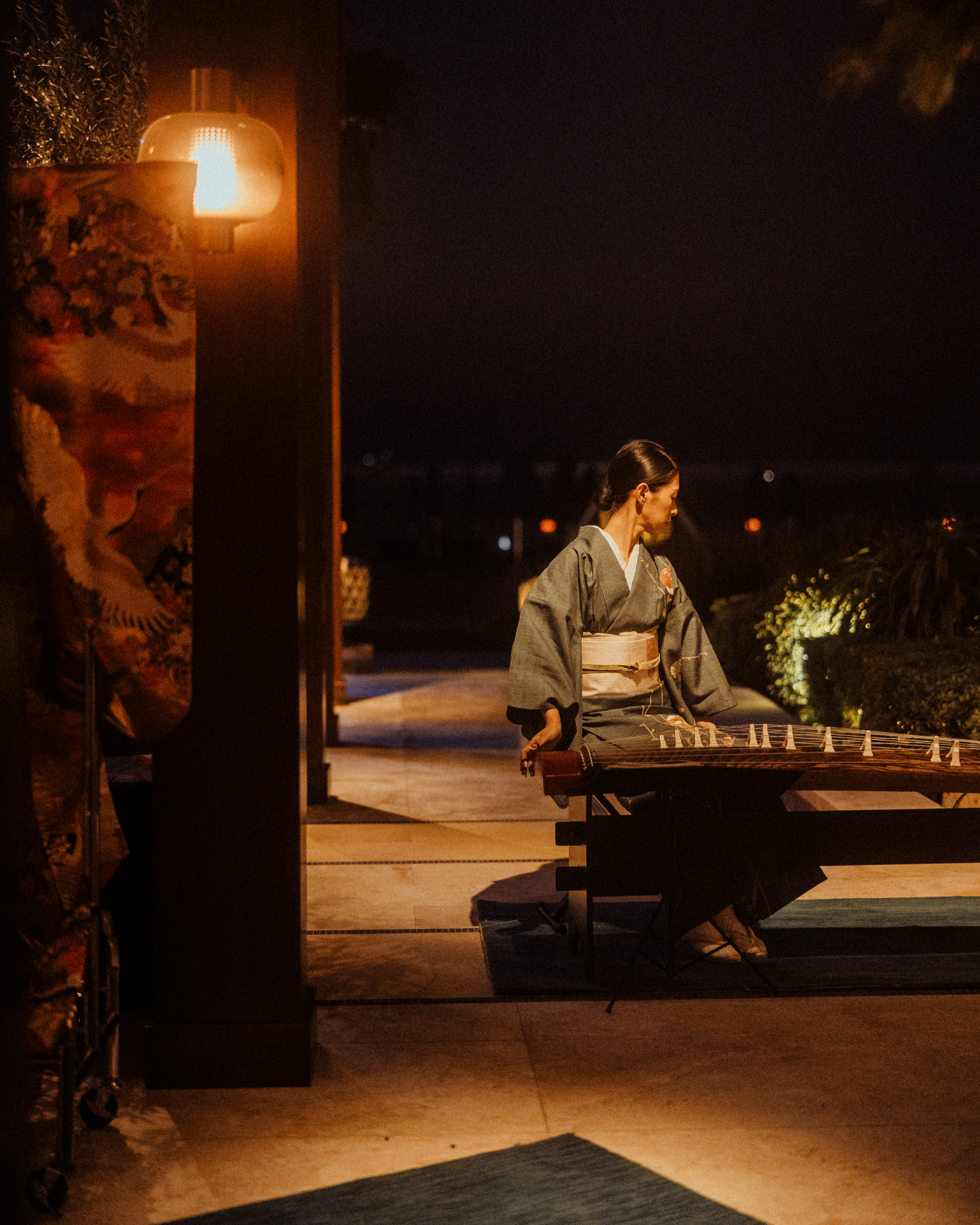 a lady that is playing koto