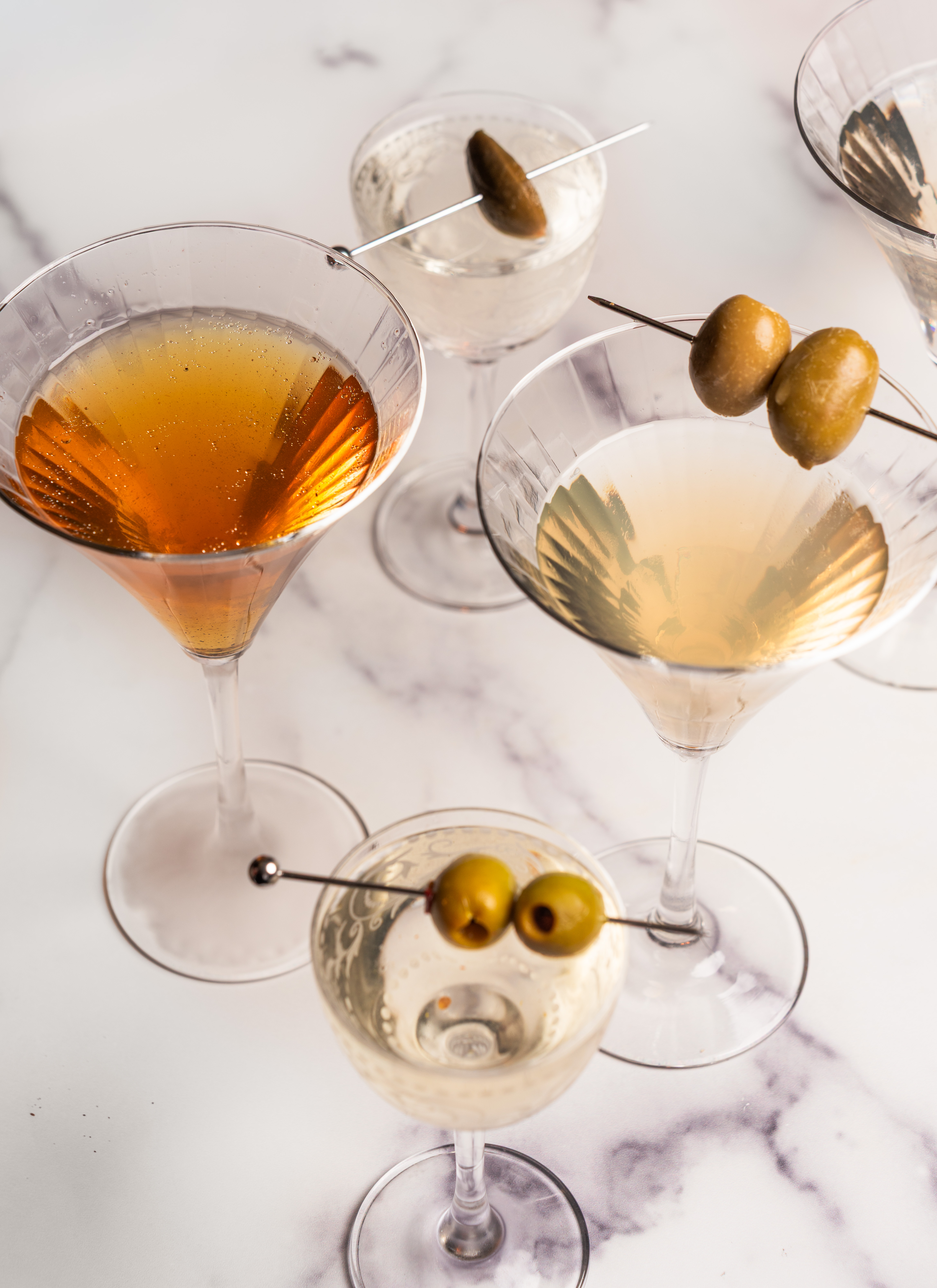a group of martini glasses with olives on them