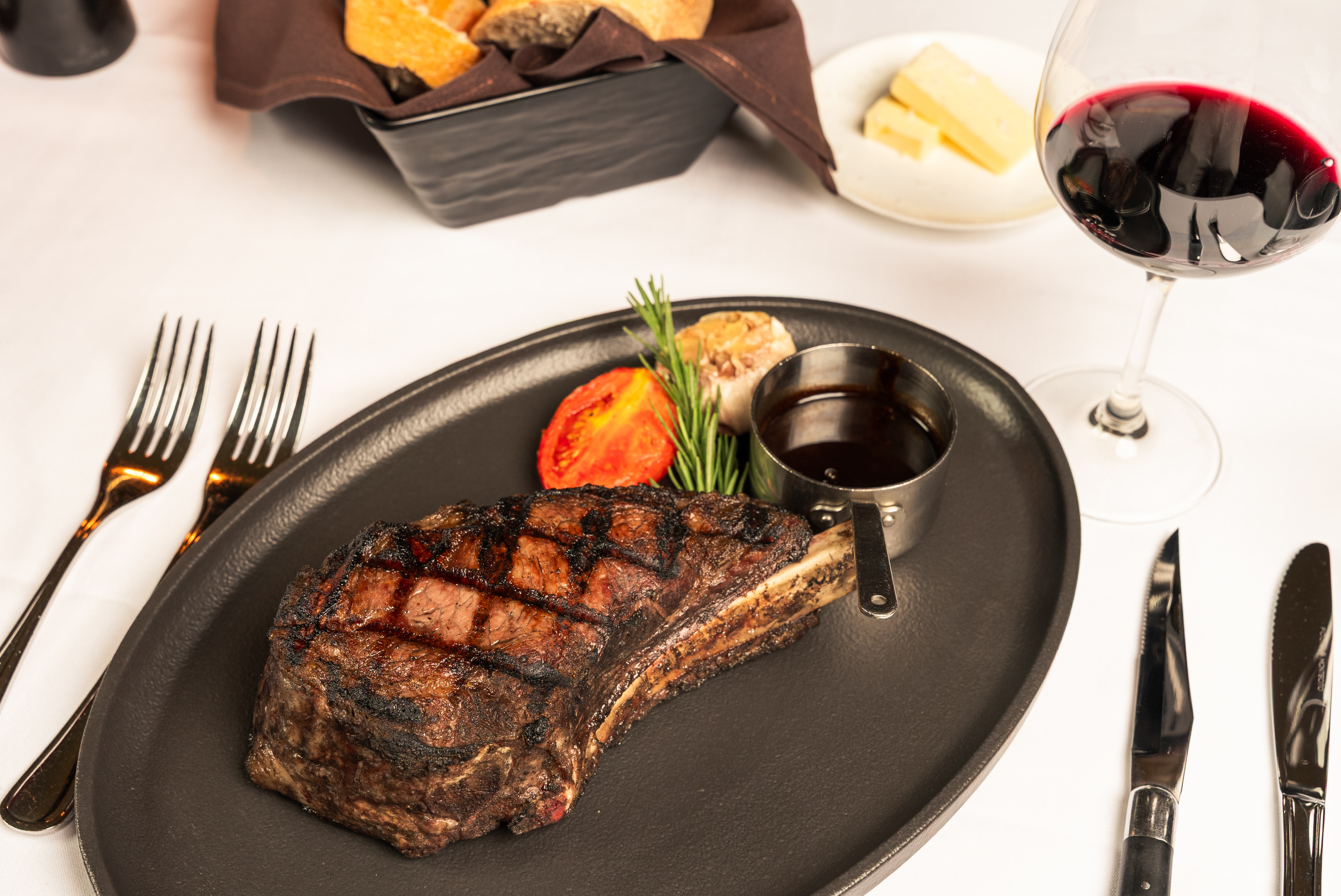 a steak on a plate with a glass of wine