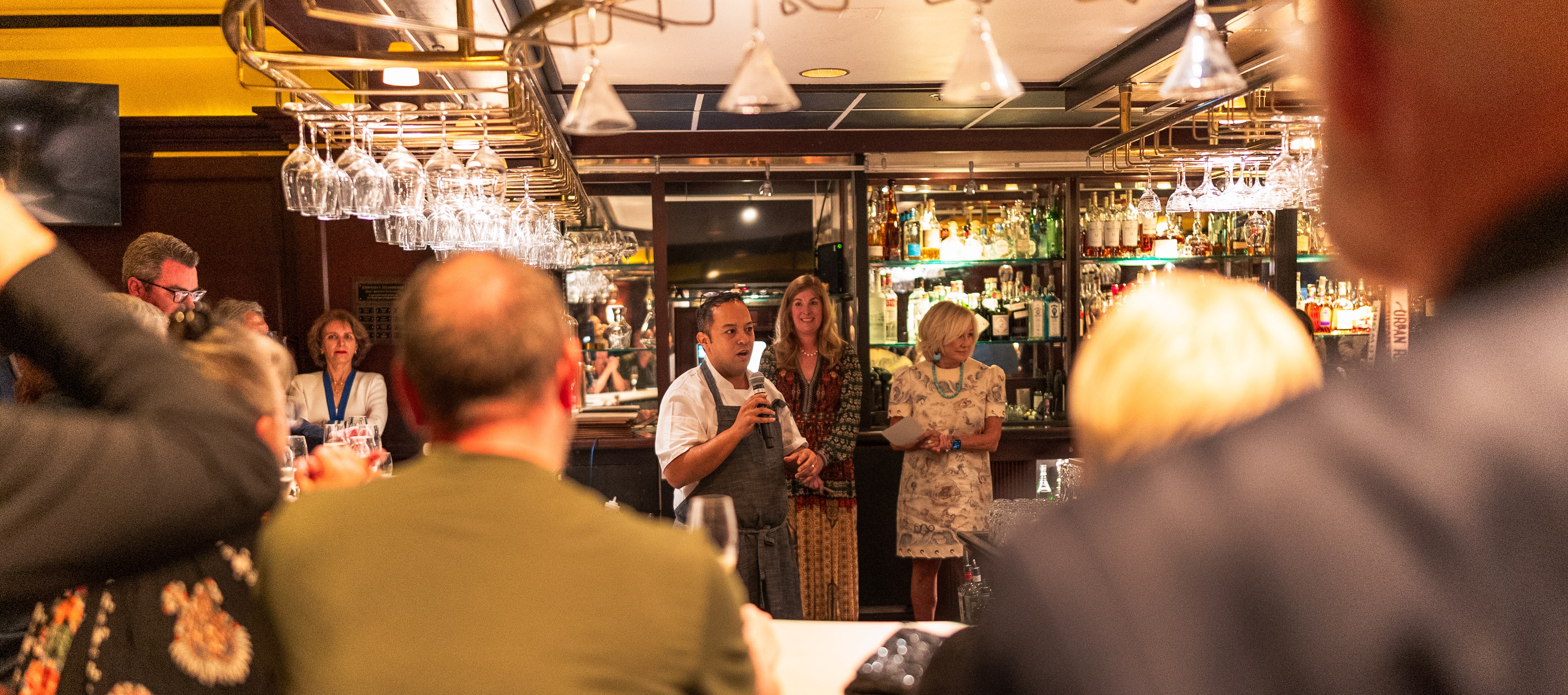 chef talking to guests at a wine dinner