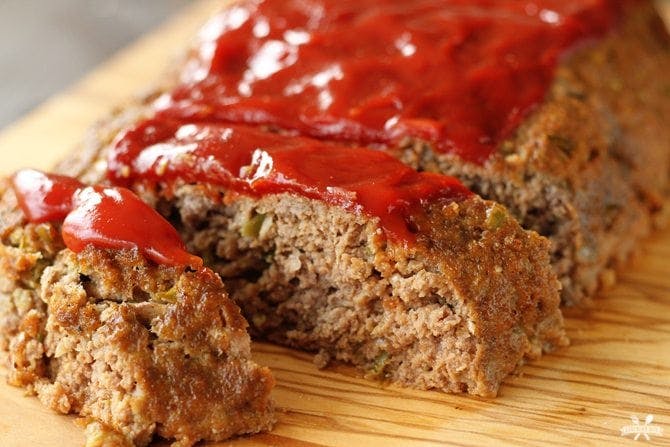 a closeup of sliced cooked meat and topped with ketchup