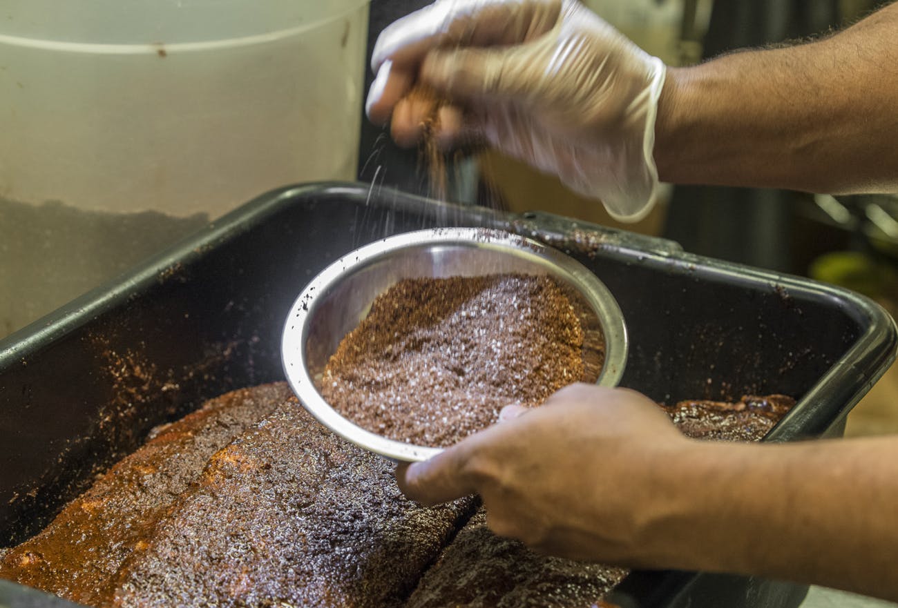 a person pouring spices in a bowl
