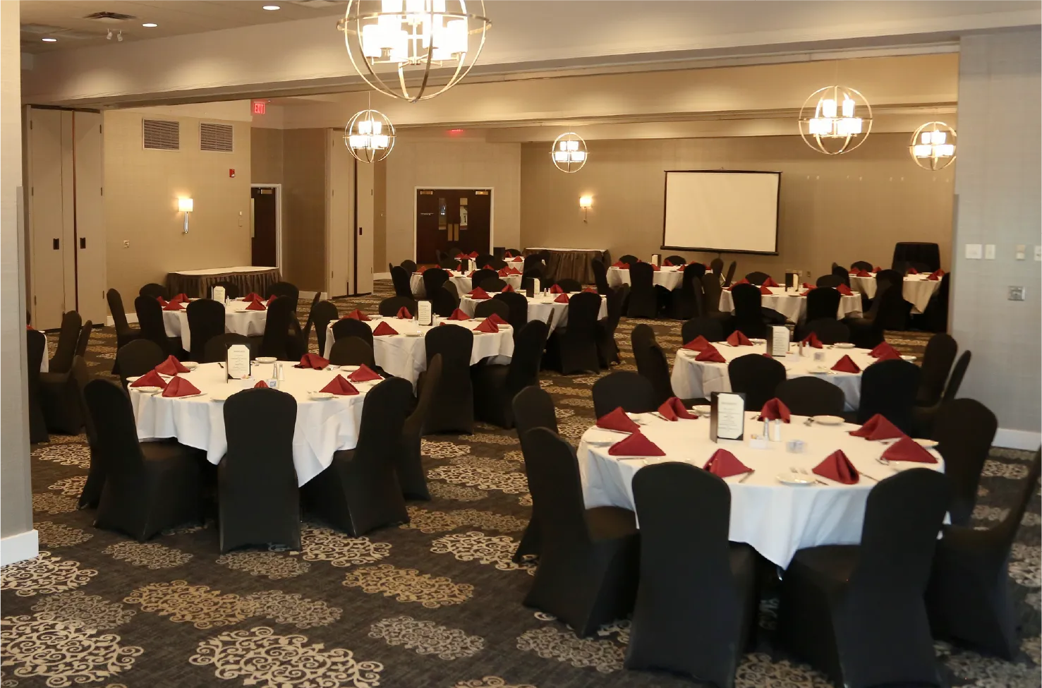 Banquet Room B meeting space with round tables and projector screen