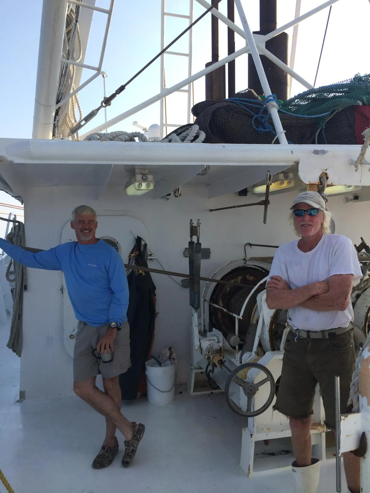 two men on a boat posing for the camera