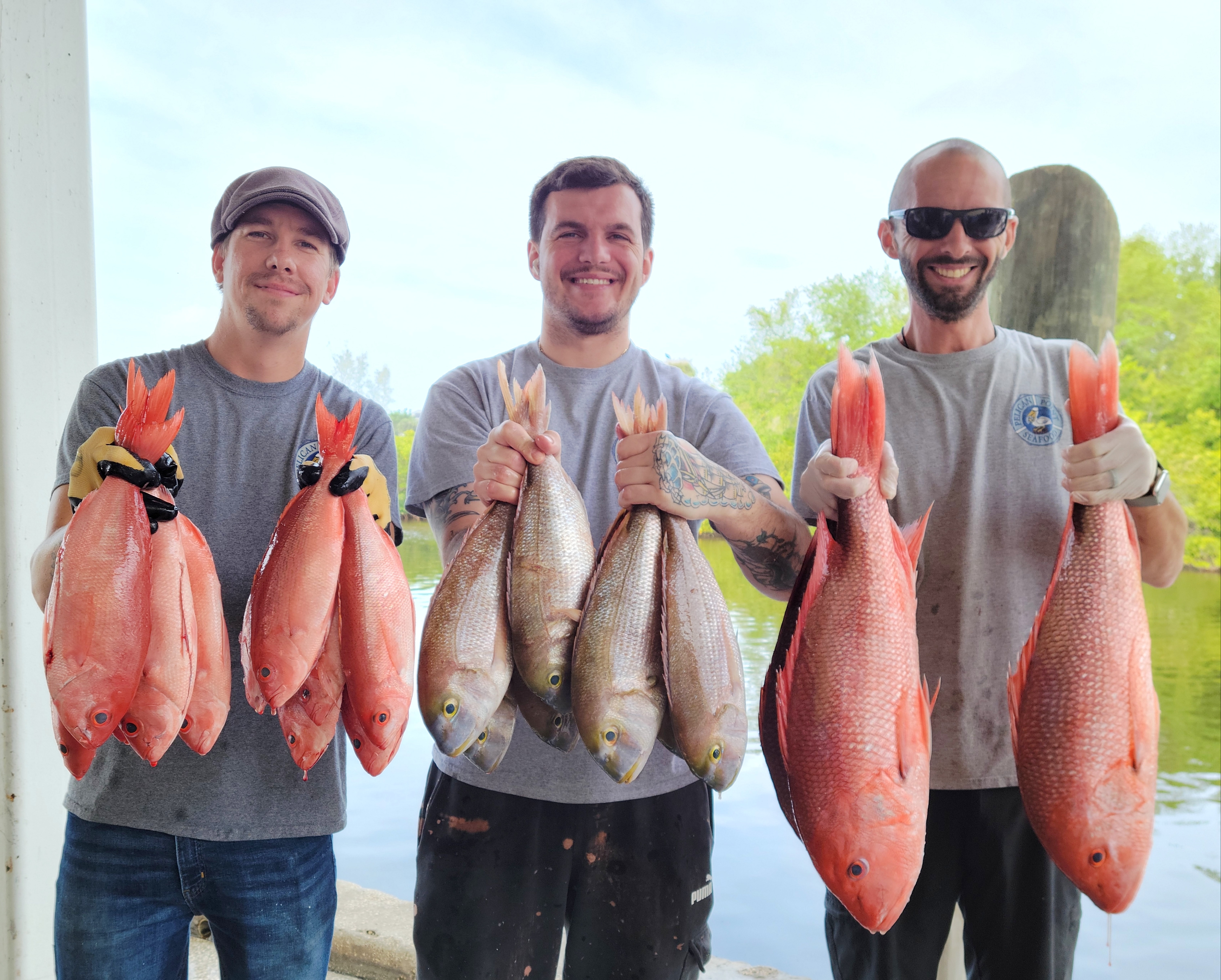 a group of people standing next to a person holding a fish
