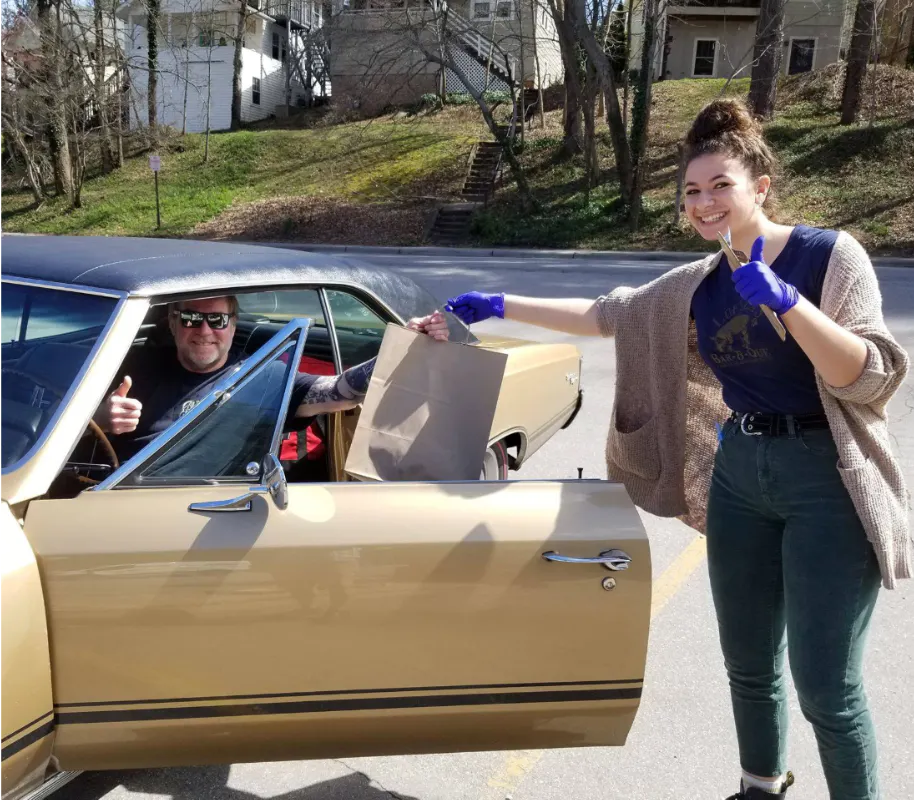 a man and a woman standing next to a car