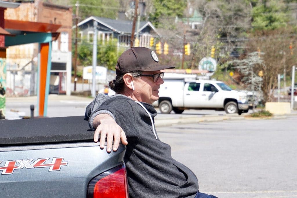 a man sitting in a parking lot