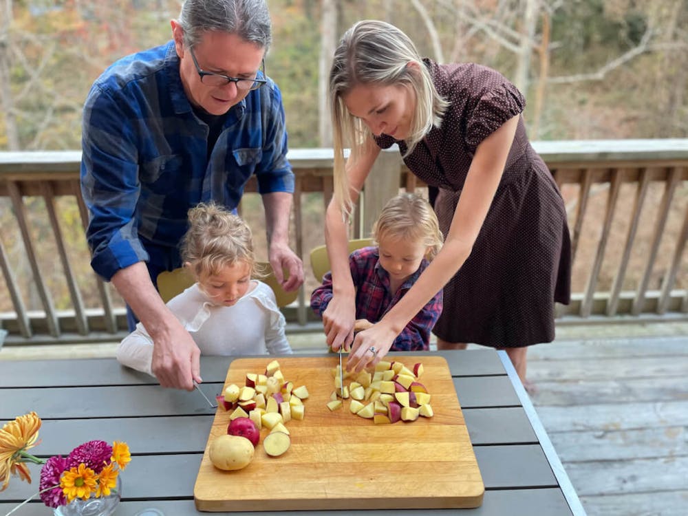 a group of people standing on top of a wooden cutting board