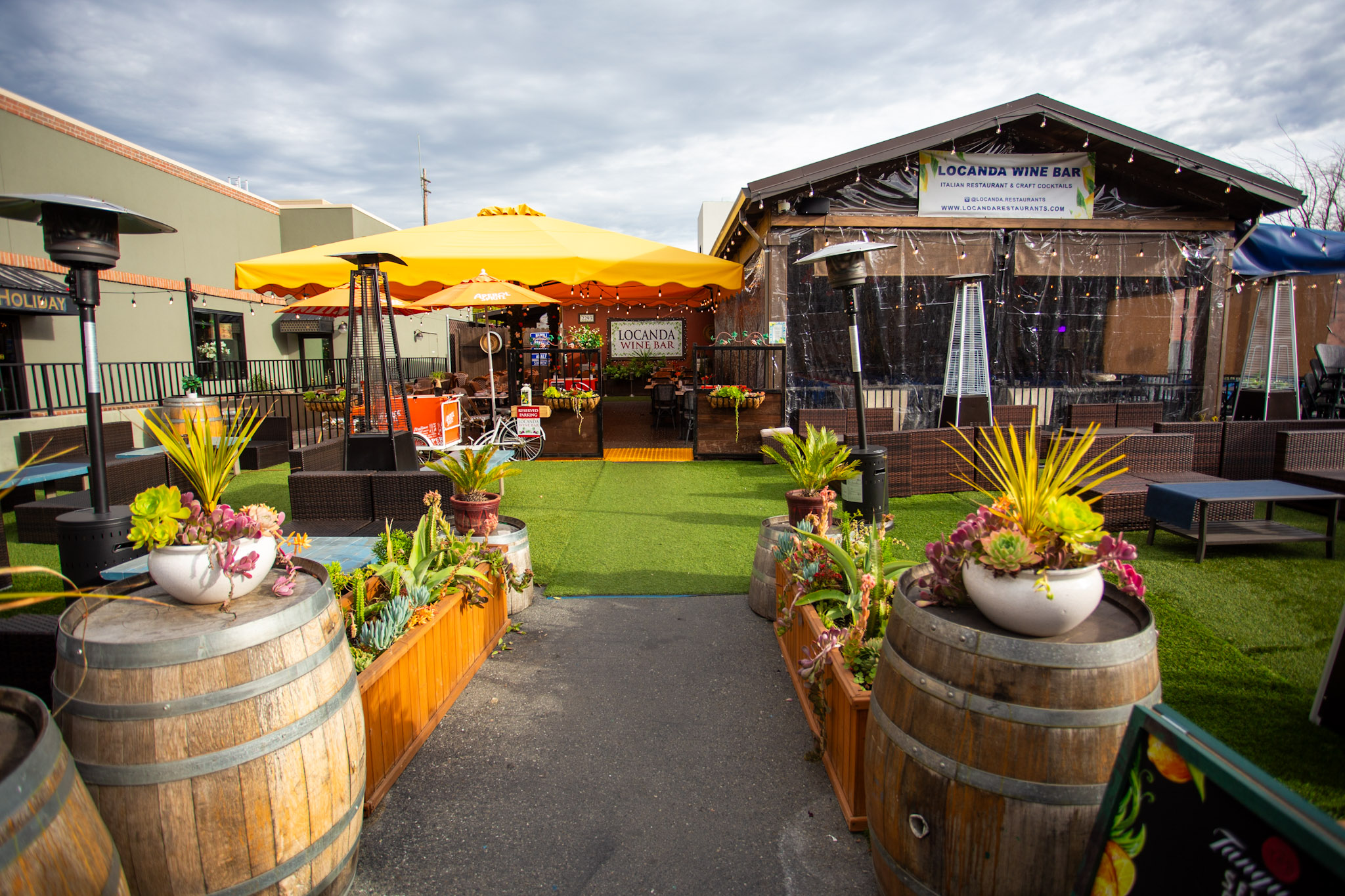 a patio with barrels and plants