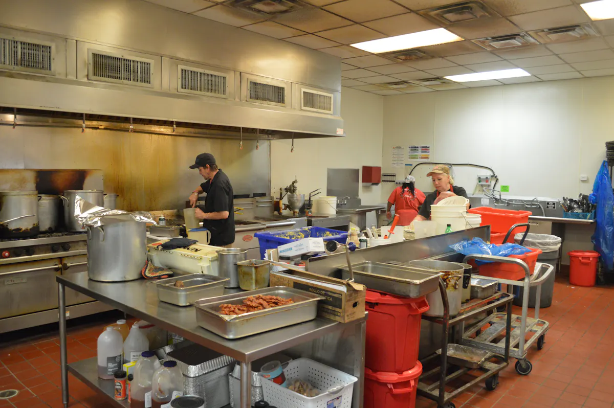 a group of people preparing food in a kitchen