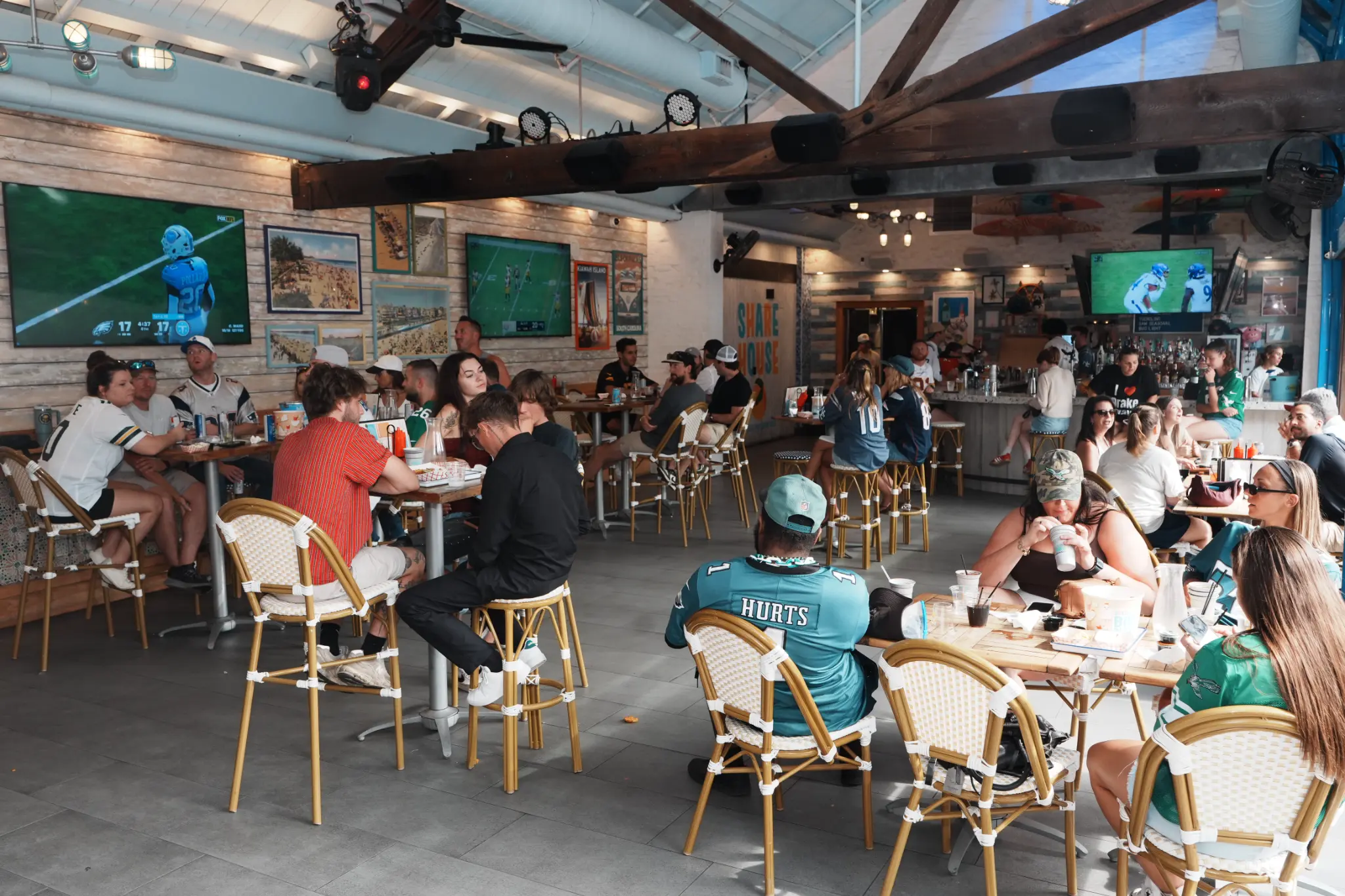 The Share House dining room during football viewing with guests at tables and games on the televisions
